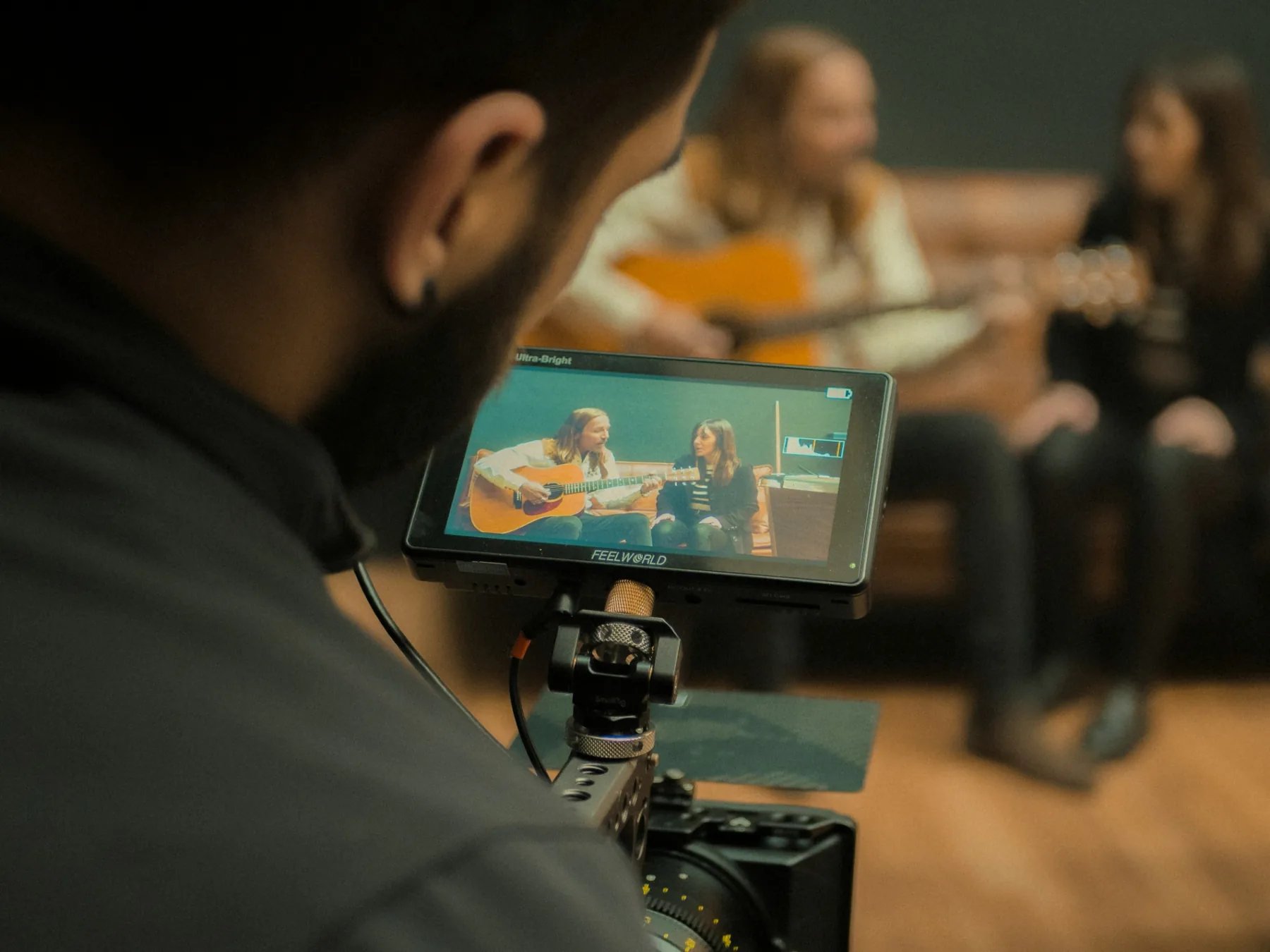 A camera monitor framing musicians during a creative shoot